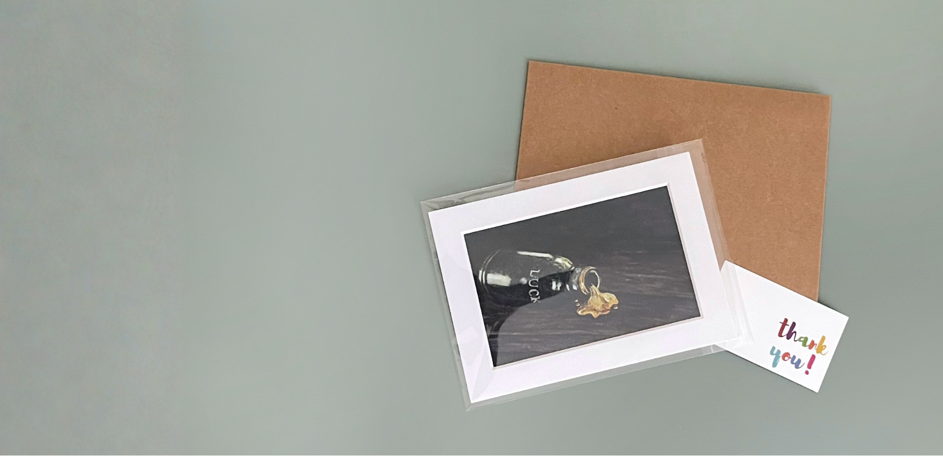 Matted art print of glass bottle labeled "lucky" pouring out gold liquid