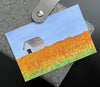 Postcard with watercolor painting of a field of daffodils with a barn and blue sky. 